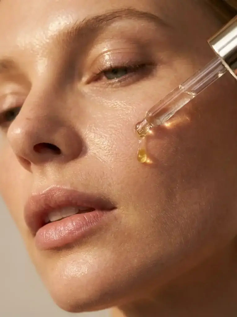 Blonde Frau Skincare MAP closeup Gesicht 1 Tropfen Serum aus der Pipette